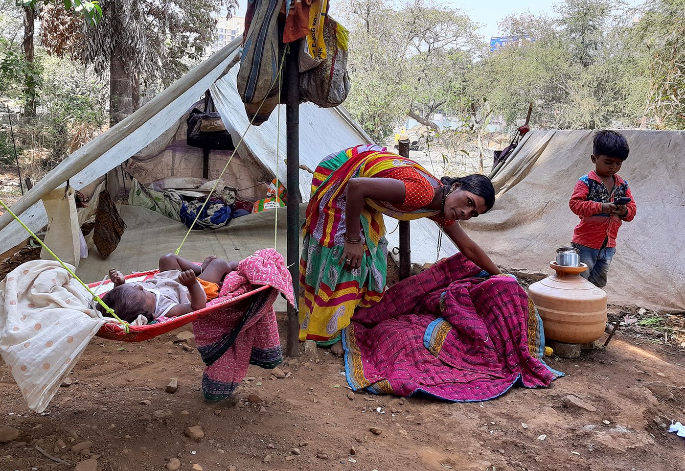 Maya with baby Sheetal and her son Avinash outside their tent