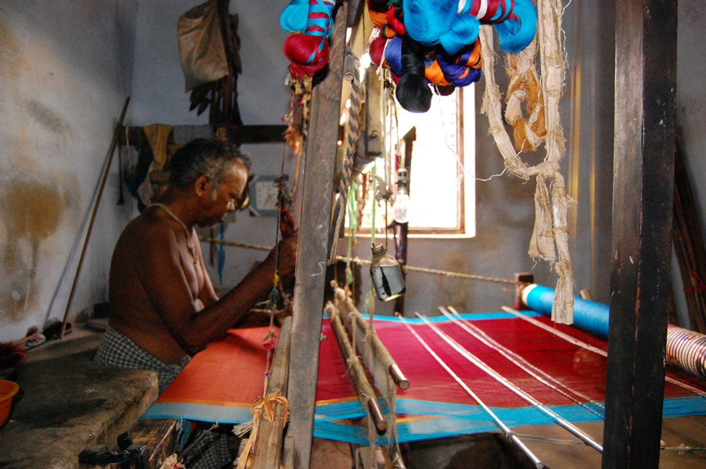 A weaver weaving silk sarees on a handloom