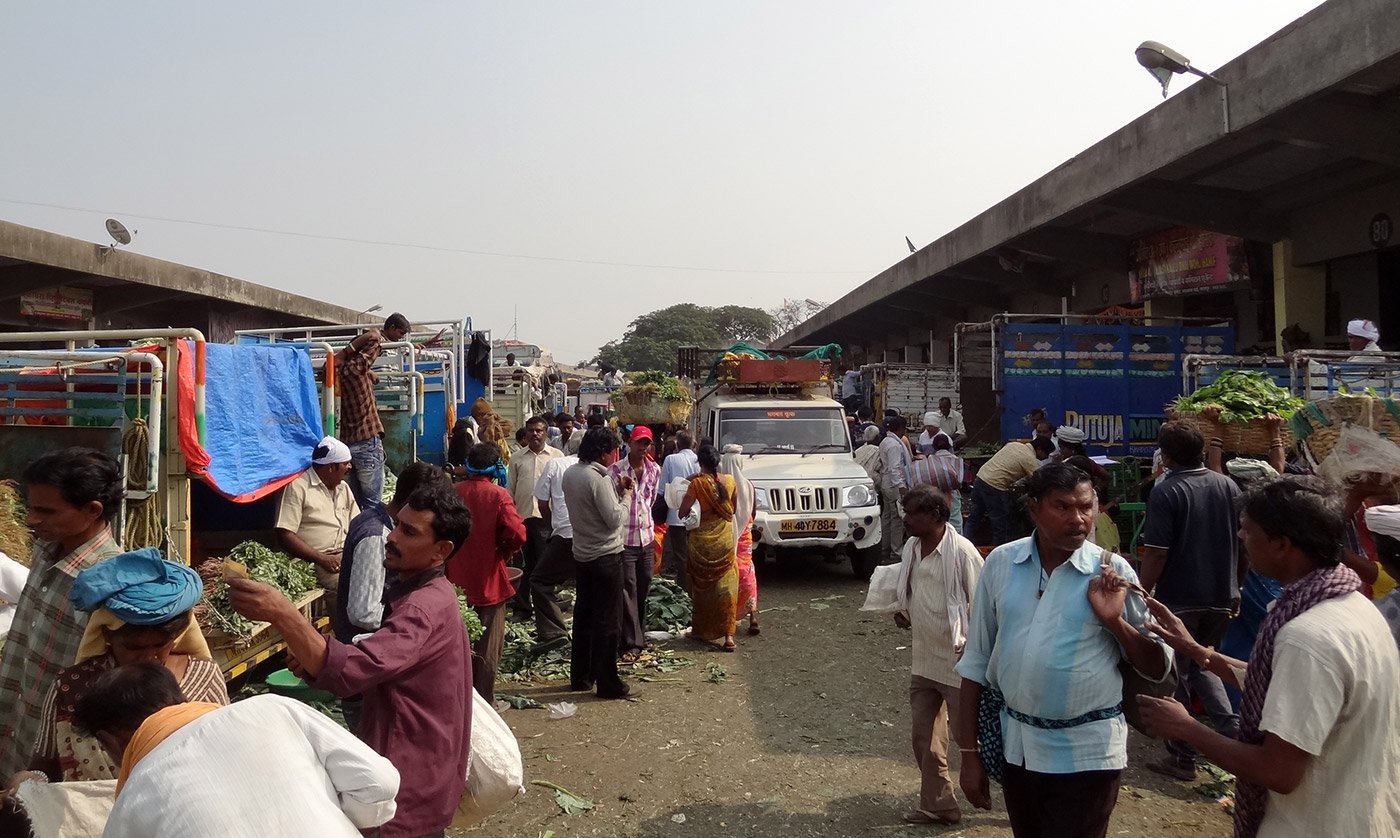 Vegetable market with crowds of people and automobile