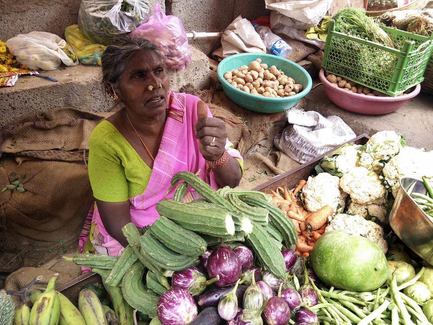 An elderly woman selling vegetables