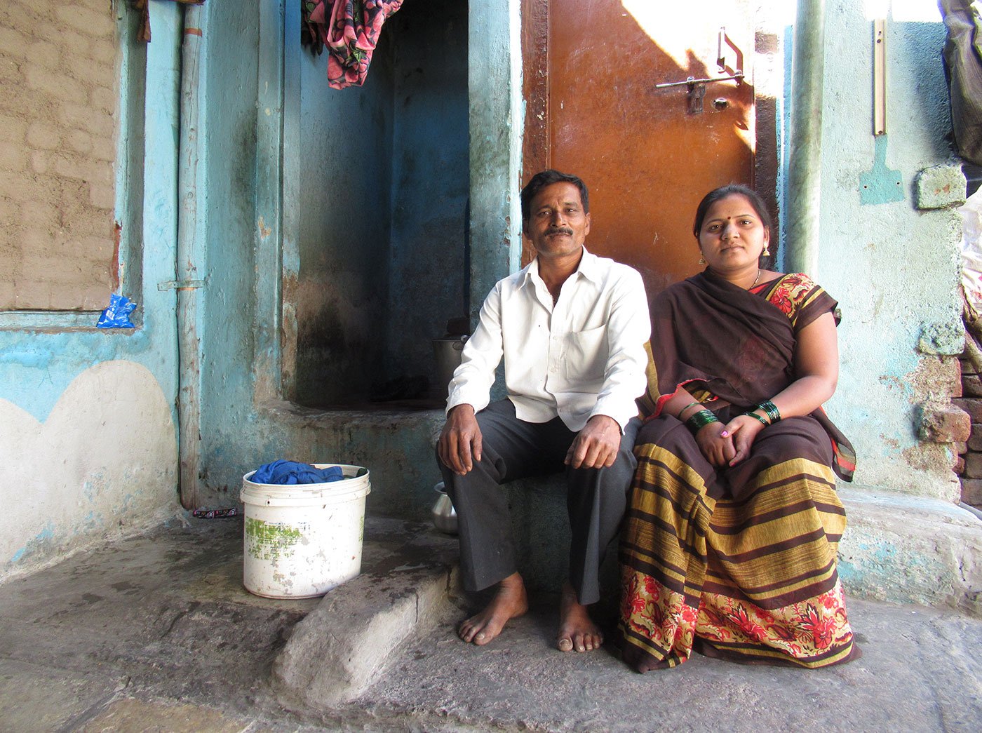 Sarika and Dayanand Satpute sitting outside a house
