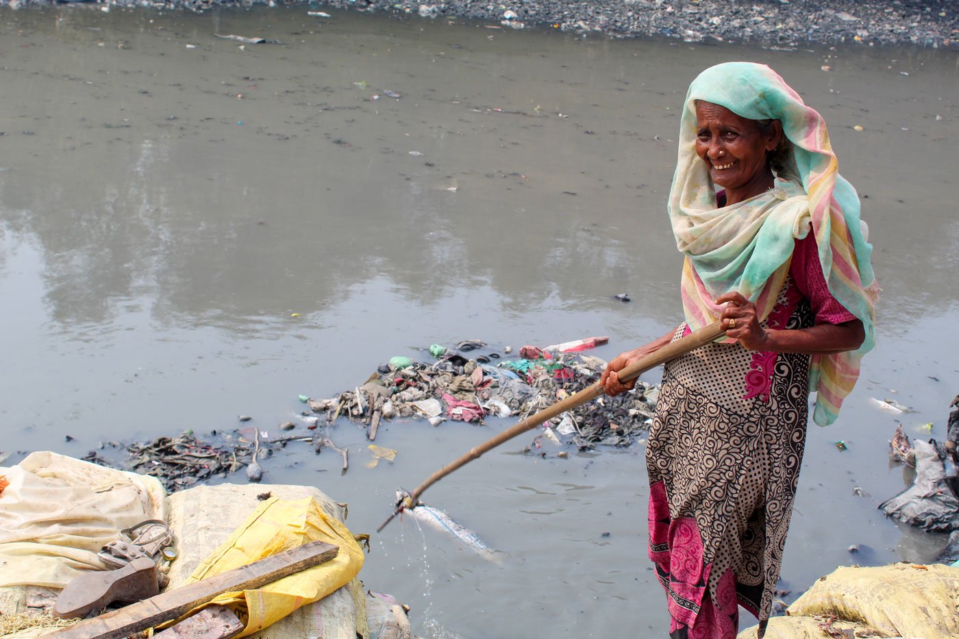 Kitabun Nisa Shaikh fishing out pieces of plastic from the nallah with her stick