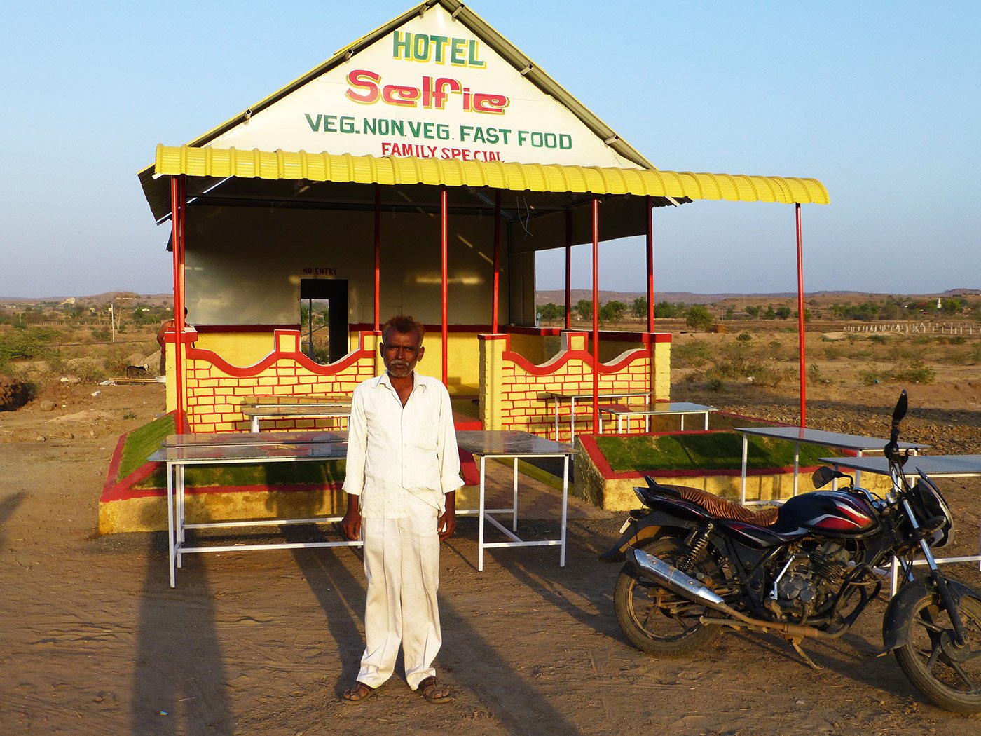 Rafiq Sheikh standing in front of his roadside hotel
