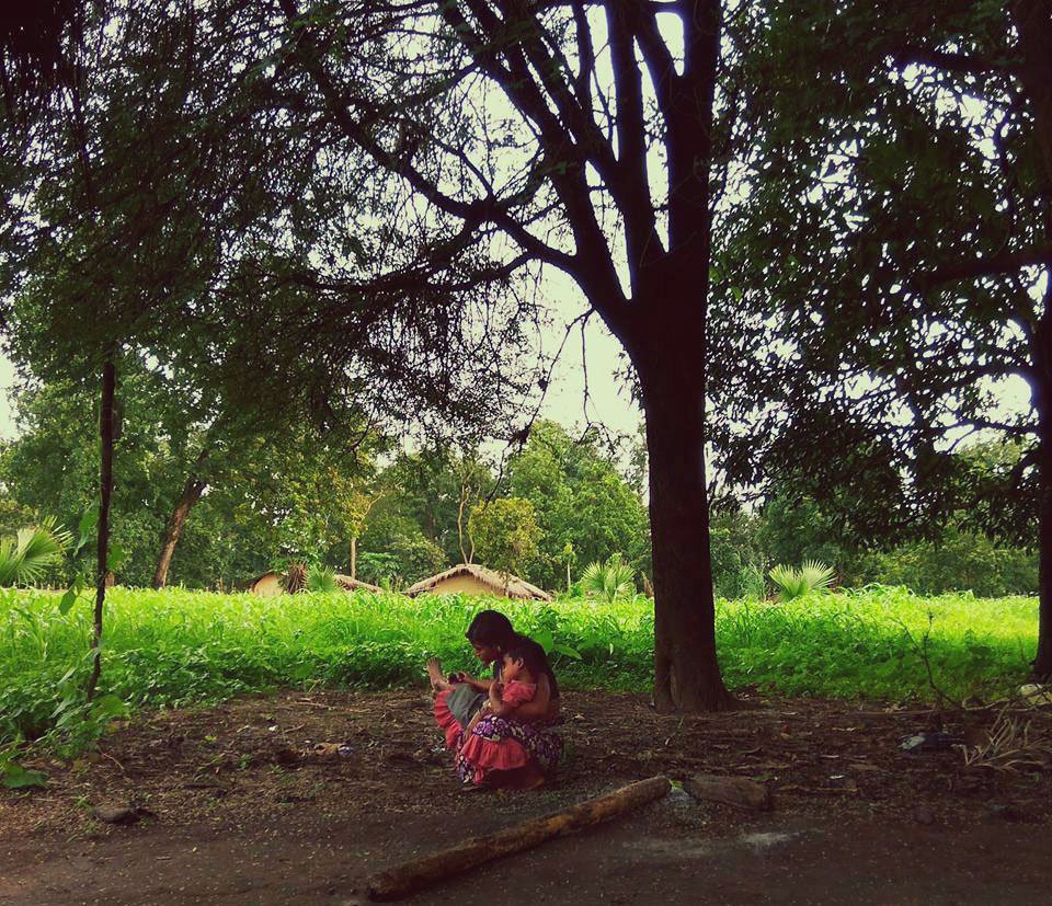 A woman with her child under a mahua tree in Farsegarh village, Bijapur district; she is a forest dependent farmer who was returning from the weekly market or haat with her child