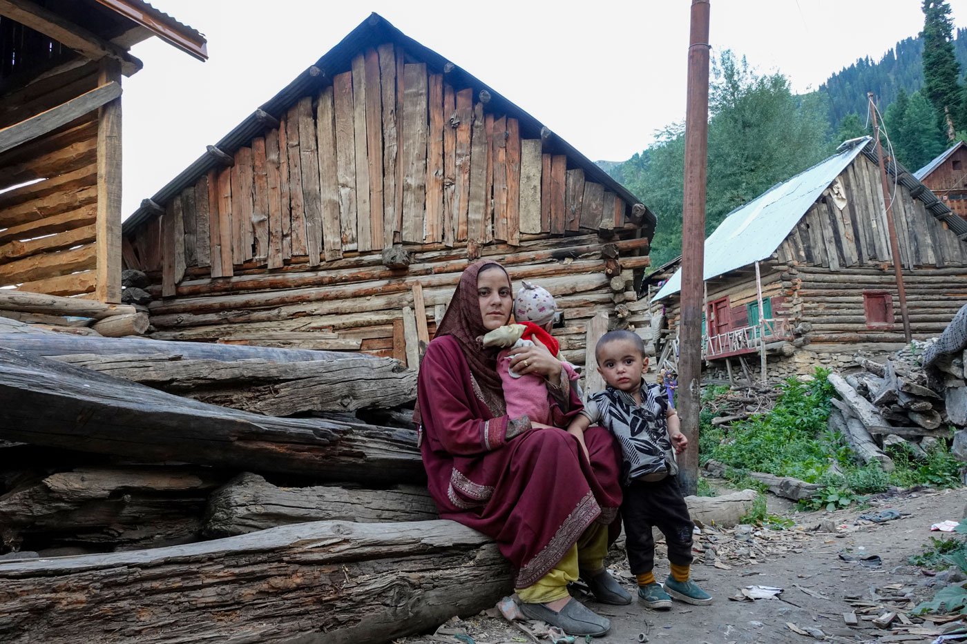 Shameena with her two children outside her house. Every single day without sunlight is scary because that means a night without solar-run lights. And nights like that remind her of the one when her second baby was born, says Shameena