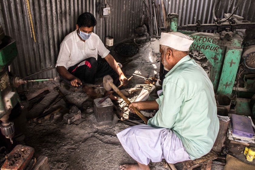 Dilawar Shikalgar – here with and his son Salim – uses a hammer to shape an iron block into a nut cutter or adkitta of distinctive design and durability

