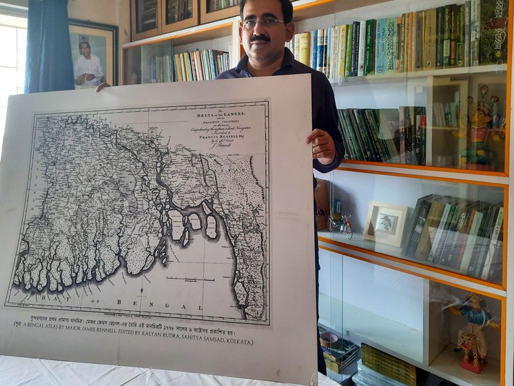 Lahiri holds the first map of the Sundarbans (left) prepared by Major James Rennel in 1778. In his collection (right) are many books on the region