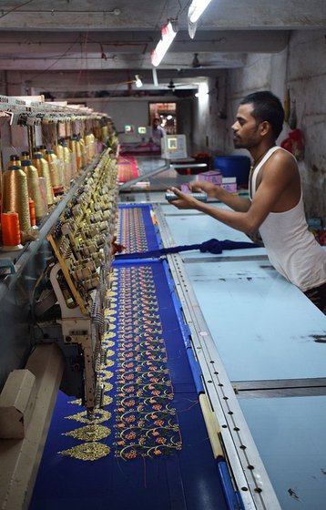A young worker works on an embroidery machine in a unit in Fulwadi