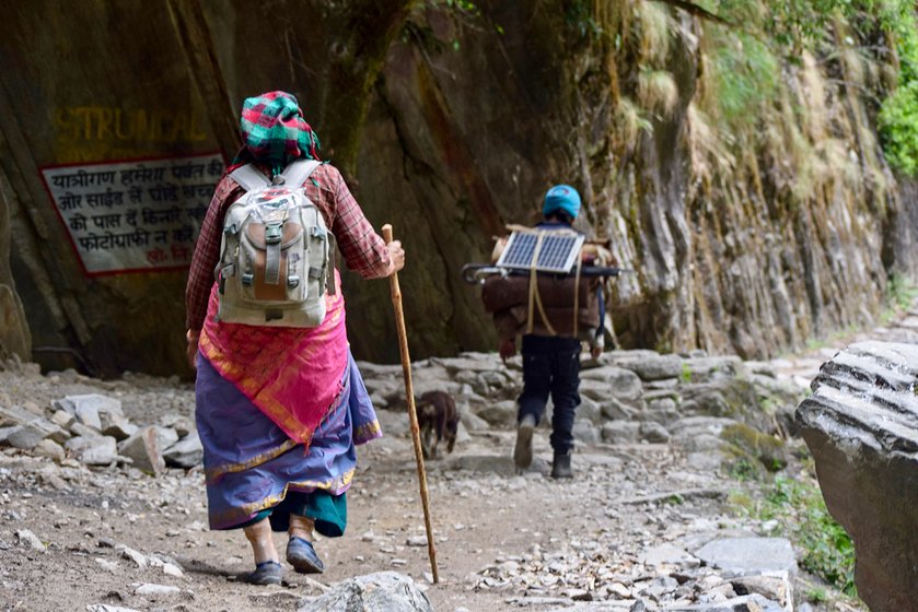 Sukhmati Devi is trudging along the 70 km route to her village Kuti in Vyas valley in Dharchula in Pithoragarh district of Uttarakhand. Before her, a porter is carrying her basic necessities including grains, packet of biscuits and a solar panel for charging of phone and torches