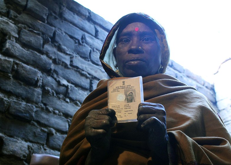 A woman showing her Voter ID card