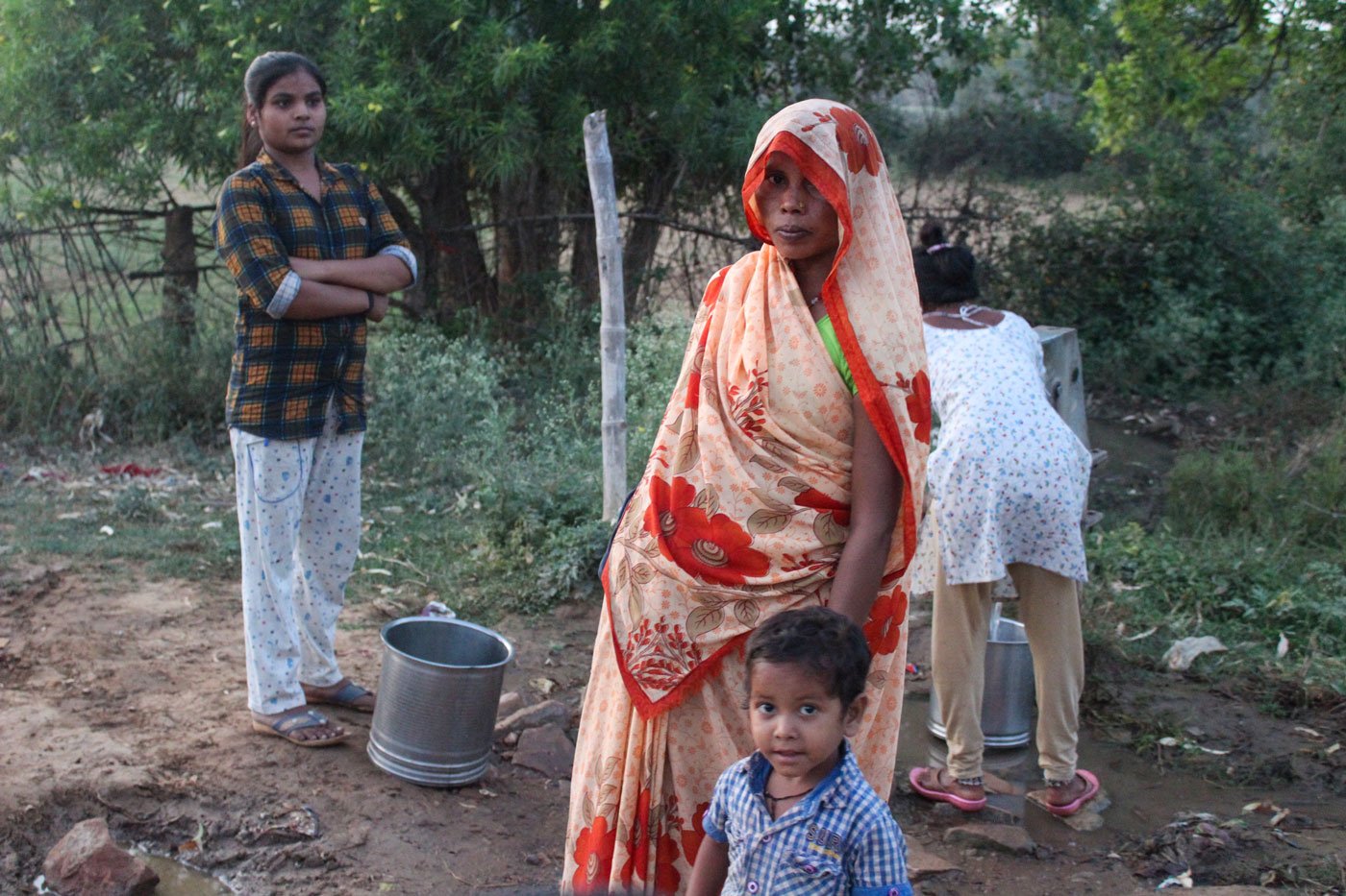 Sushma Devi with her youngest child at the village hand-pump; she ensures that her saree pallu doesn't slip off her head

