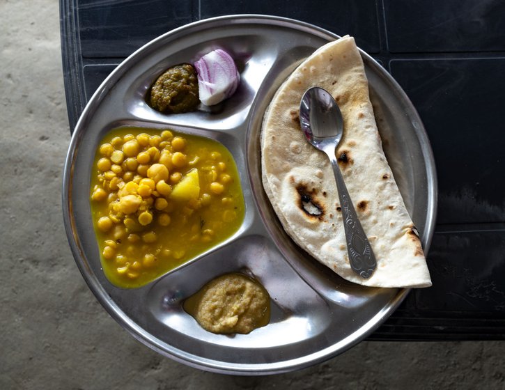 Lunch at Hotel Hazarika is a wholesome, delicious spread comprising dal, roti, chutneys, an egg, and a few slices of onion
