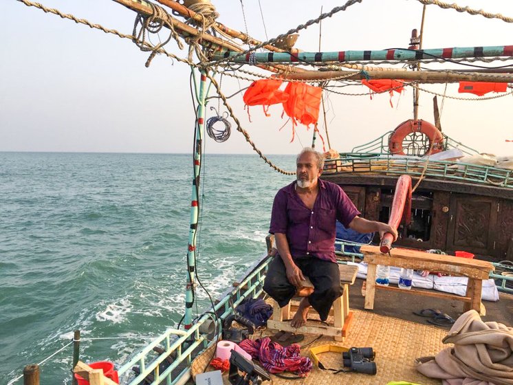 An owner-captain of a modified fishing boat, Sobahan Shordaar guides his boat FB Manikjaan through the waters of coastal Bangladesh