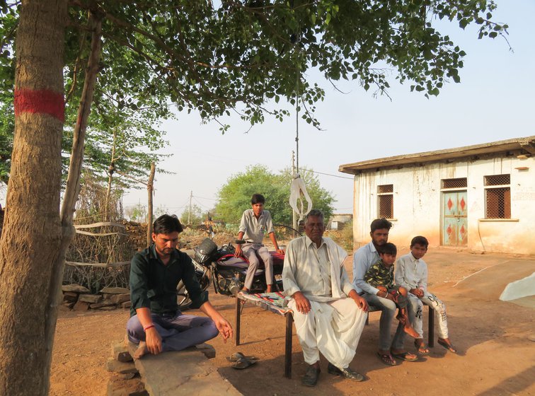 Raghulal (seated on the charpoy), with his son Sultan, and neighbours, in the new hamlet of Paira Jatav set up on the outskirts of Agara village