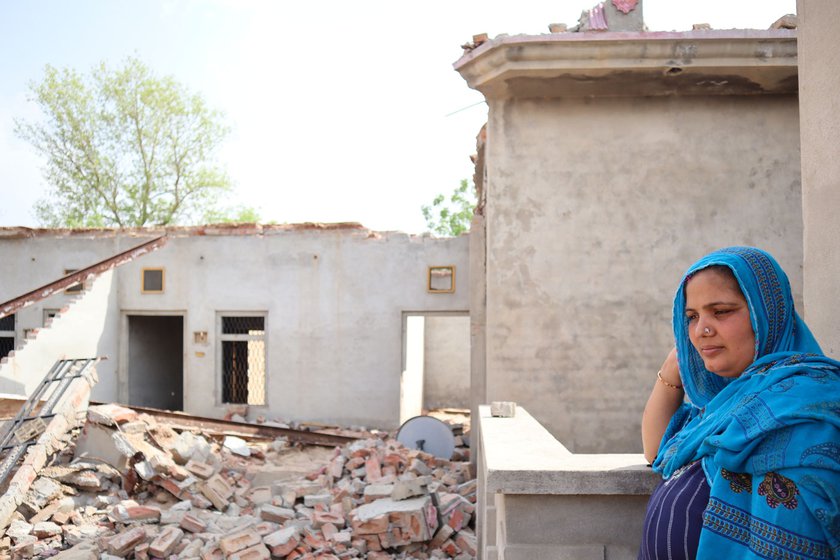 Right: Baldev Kaur’s younger daughter-in-law Amandeep Kaur next to the shattered walls of the destroyed house