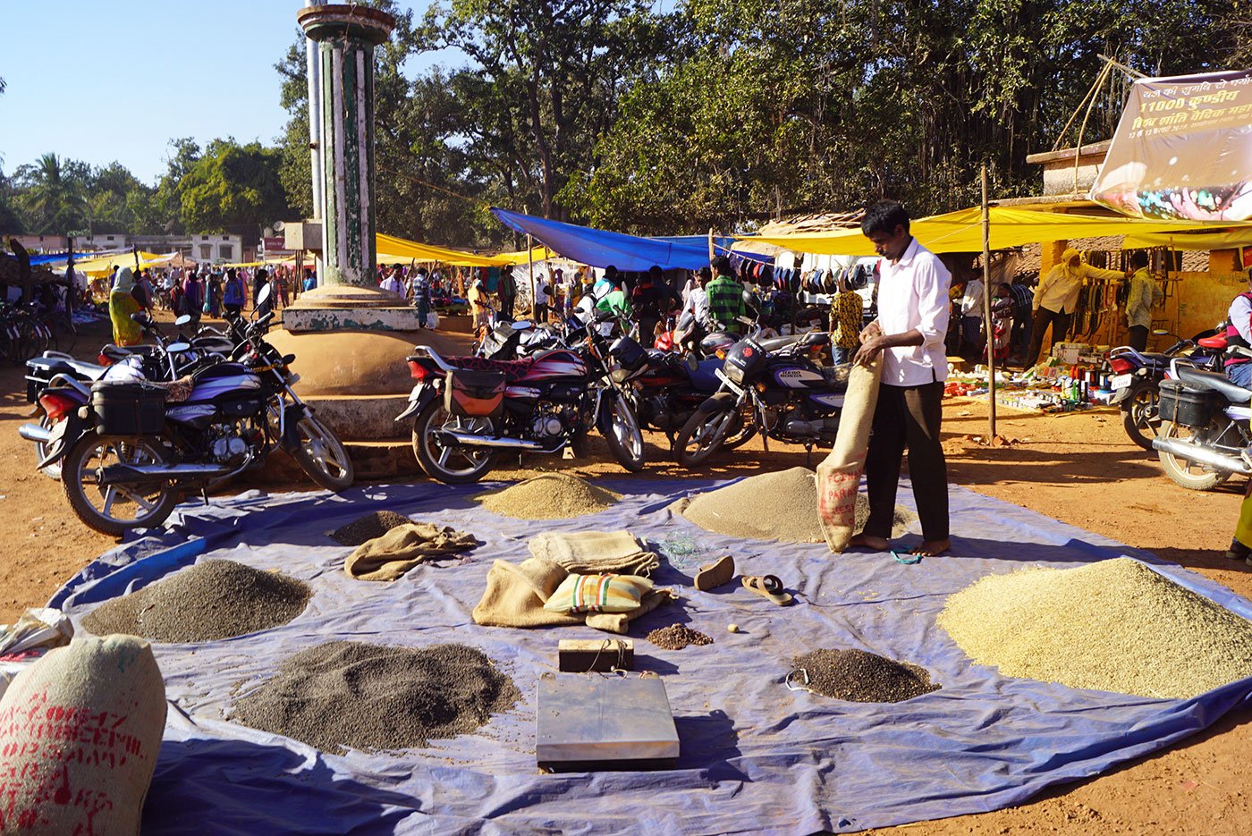 A trader sorting out grains at Amabeda haat
