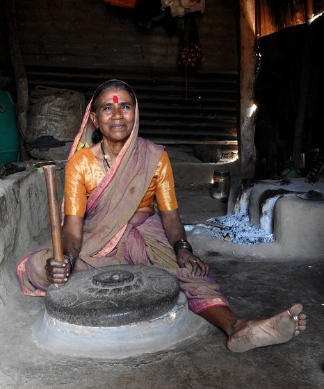 Woman sitting on the floor of a house with a grindmill