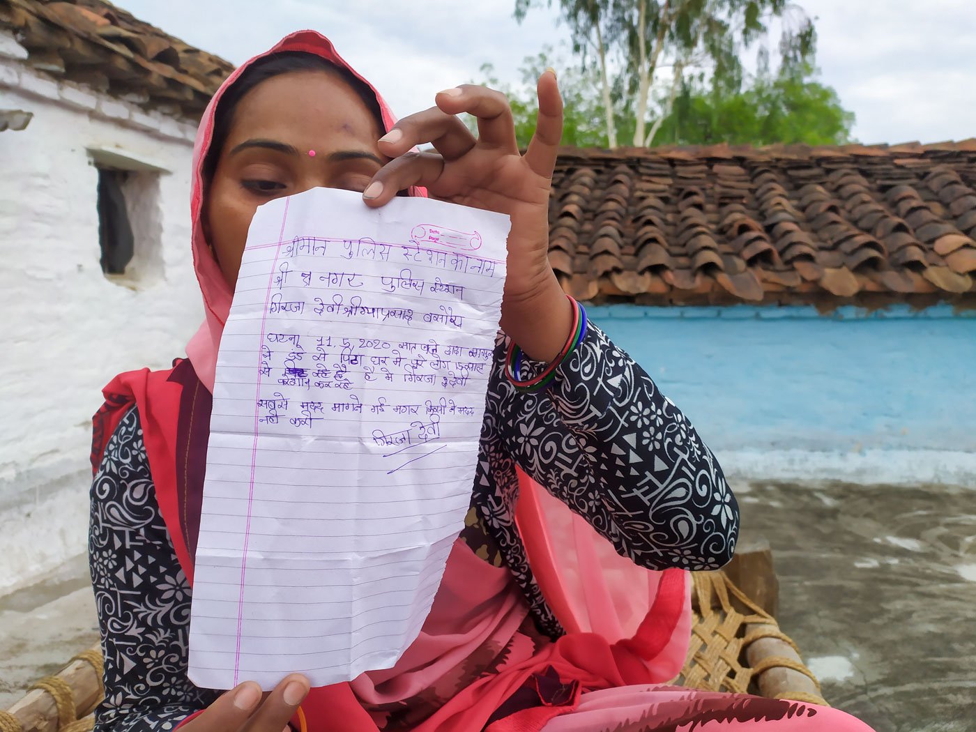 Girija with the letter of complaint for the police that she had her 14-year-old daughter Anuradha write on her behalf 

