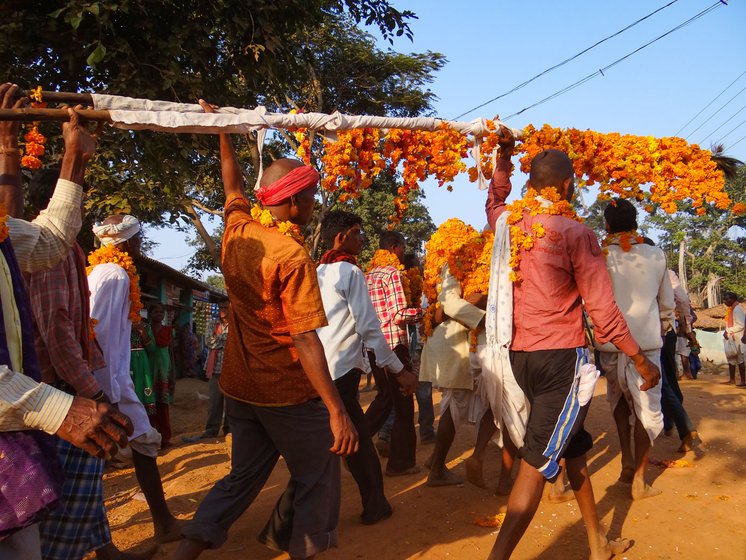 A floral procession for guardian deities at a madai (harvest festival) in Dhamtari.