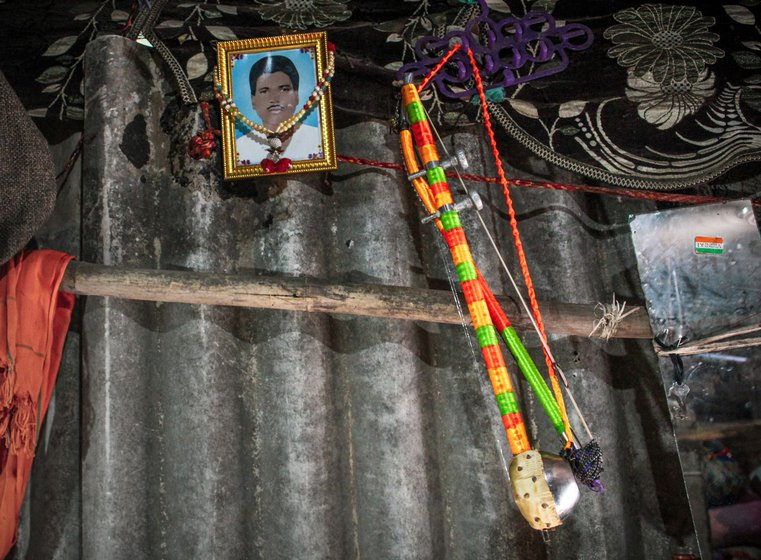 A photograph of Kishan's father Mitaji Jogi hangs on the wall of his home, along with the sarangi he learnt to play from his father.