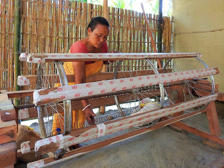 Sama tinkering with the warping drum that has recently been installed at her home. The warping drum is used to prepare the vertical yarn known as ‘warp’, which is later loaded on the loom