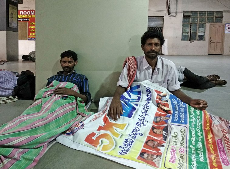 Kota Veera Vasantha Rao and Kotamarthi Yesu get ready sleep on a vinyl banner in Pandit Nehru Bus Stand in Vijayawada