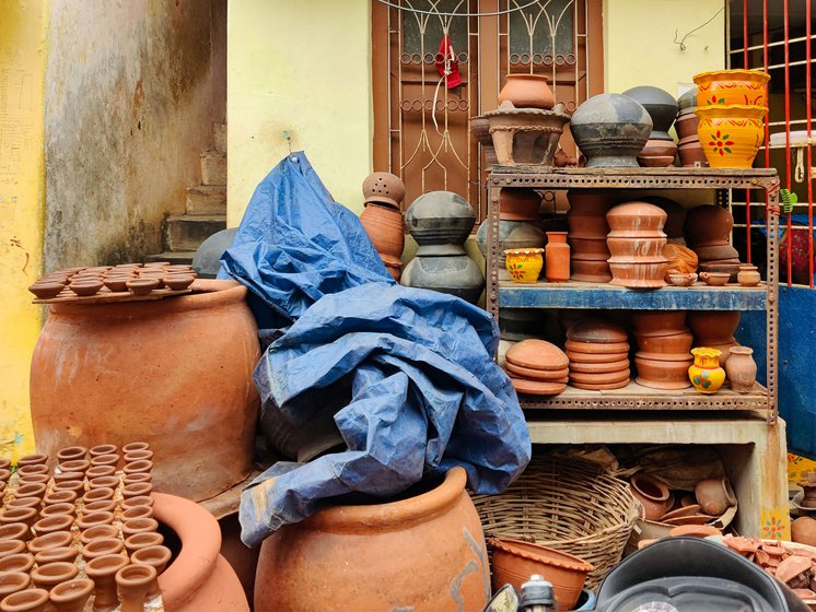 Different kinds of pots are piled up outside his home in Kummari Veedhi (potters' street)