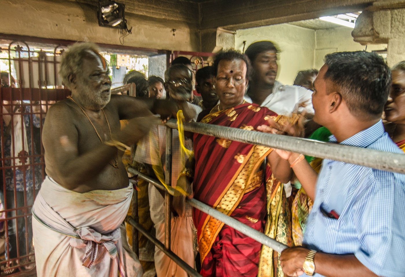 One of the priests at the Koothandavar temple begins the wedding rituals. He ties a yellow thread called thali around the neck of each aravani to consecrate her union with Aravan. 