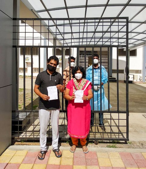 Tanuj and Shilpa with their discharge papers, outside the quarantine centre
