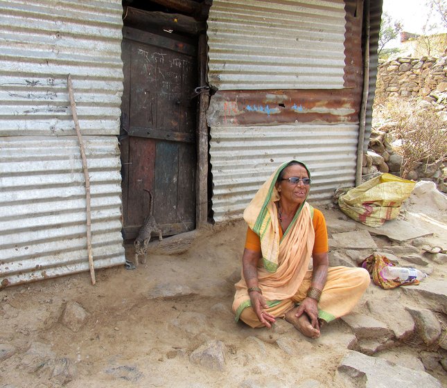 A woman sitting outside a tin hut in Hatkarwadi village in Beed district of Maharashtra