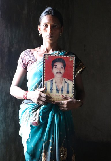 Tulshi holding a photo frame with her deceased husband’s photograph