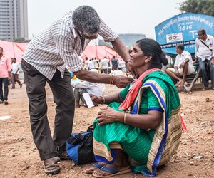 A labourer helps his wife pin the protest rally badge.