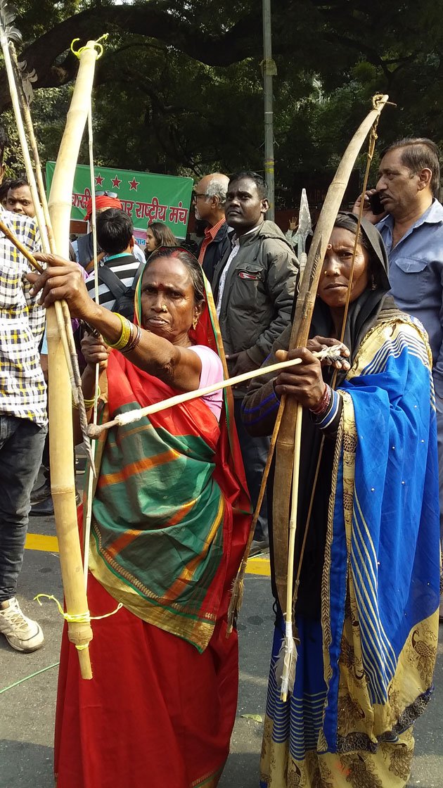 Rajkumari Bhuiya (left) of Dhuma village in UP's Sonbhadra district with the traditional bow and arrows her Bhuiya community used to defend their land. She is a member of the All India Union of Forest Working People and a leader in organising her community to file claims to forest resources.