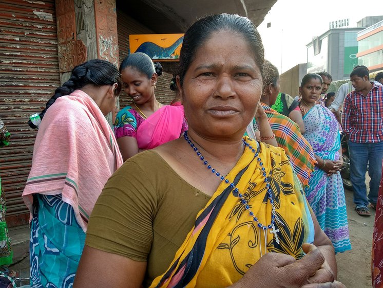 A woman standing at a street corner in Vijaywada