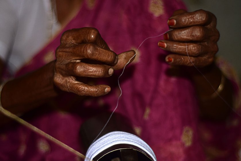 Shakuntala, 90 years old, spins the cotton thread using the charkha; she has been doing from the age of 20