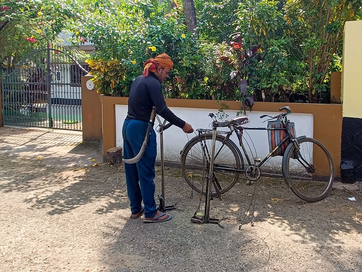Humayun attaches his apparatus to the back of his cycle when he goes from one house to the other