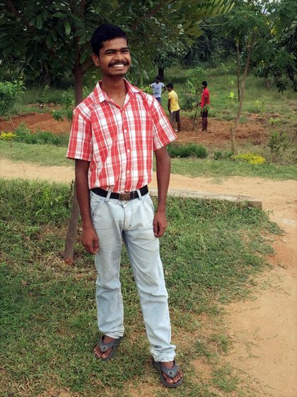 A boy smiling and standing in a garden