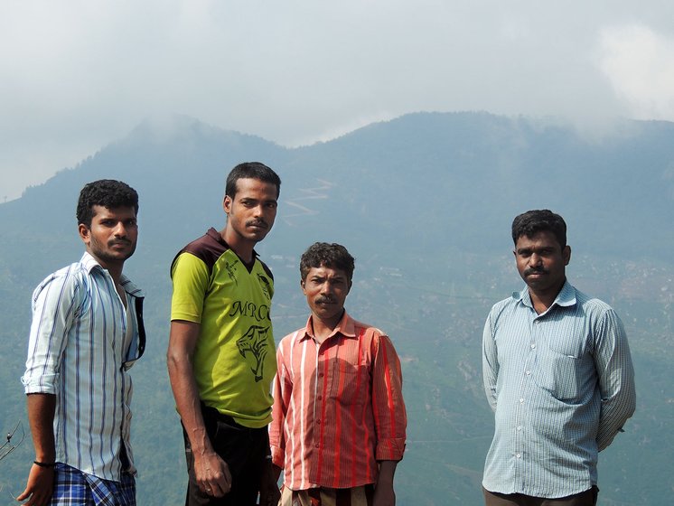 Four young men standing together with the mountains in the background