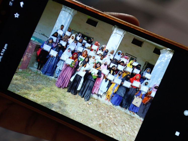Principal Qasmi showing the PARI team an old photo of Madrasa Azizia students when a cultural program was organized