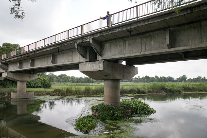 Right: Surendra Nath Awasthi standing on the bridge with the Sai river running below. The bridge is located between the villages of Parauli and Band