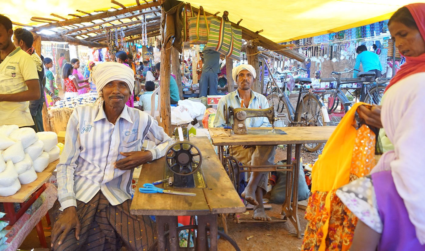 Massuram Padda (at the back) from Bagjor village and Ramsai Kureti from Ture village have brought their sewing machines here on bicycles. They will alter and repair torn clothes at the haat, and make around Rs.200-300 each