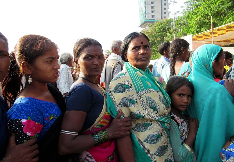 Baby Suretal (woman in green saree) waiting in line for biscuits along with some other women 