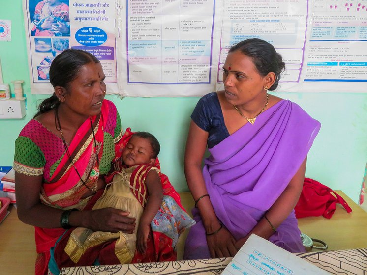 Chandrakala checking a baby at primary health centre