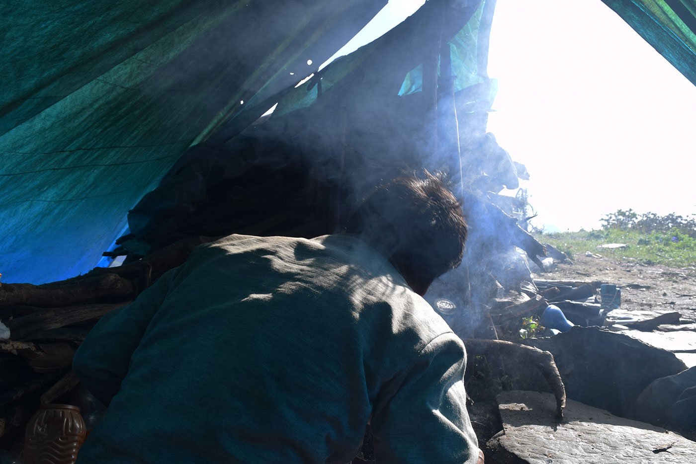 Smoke bellows from the camp while Gopal Singh makes food in the morning before he leave for the hunt