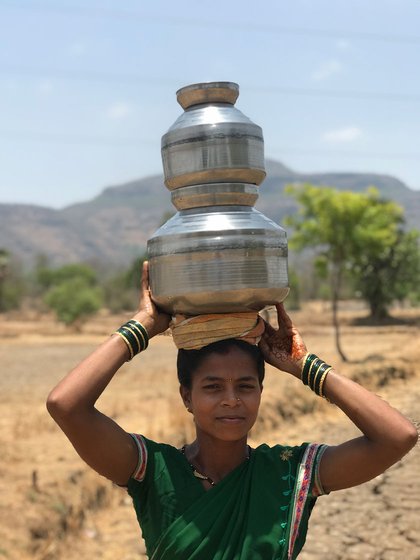 Deepali Khalpade (who shifted to Man pada) carrying pots of water on her head
