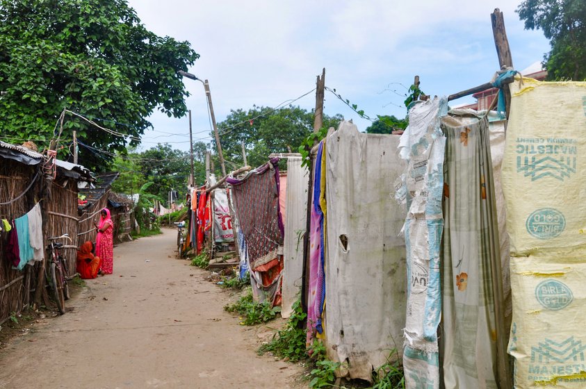 Left: Pushpa Kumari holding up the curtain to her family's toilet cubicle. Right: In the Sagaddi Masjid Road colony, a flimsy toilet stands in front of each house