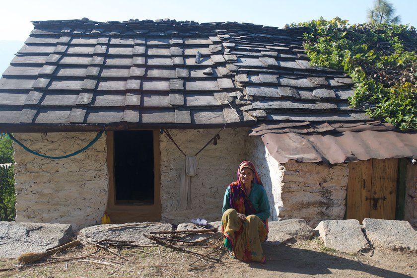 A woman sitting outside her home in a village in Uttarakhand