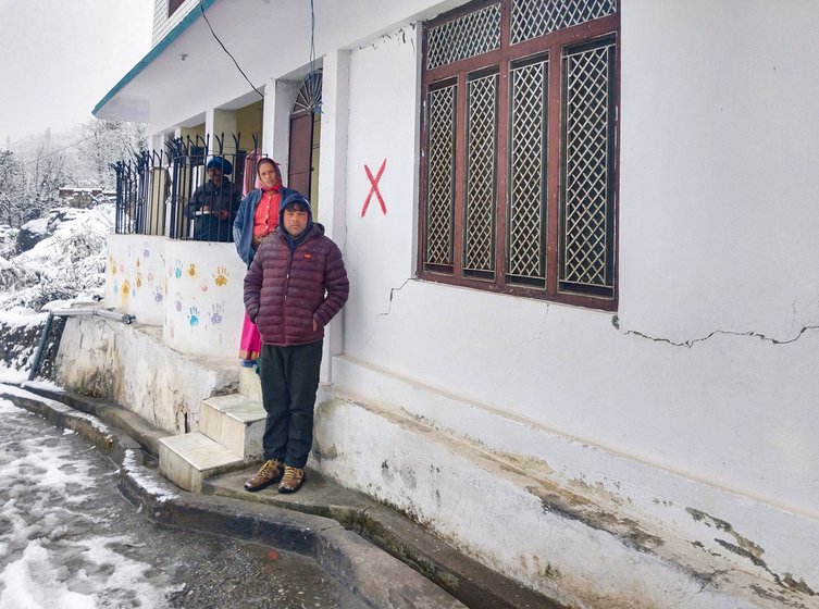 Ranjit Singh Chouhan standing outside his house in Joshimath which has been marked with a red cross signifying that it is unsafe to live in.