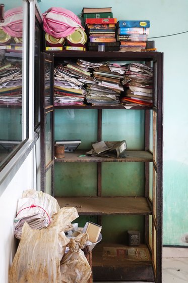 Documents and books stacked on a shelf
