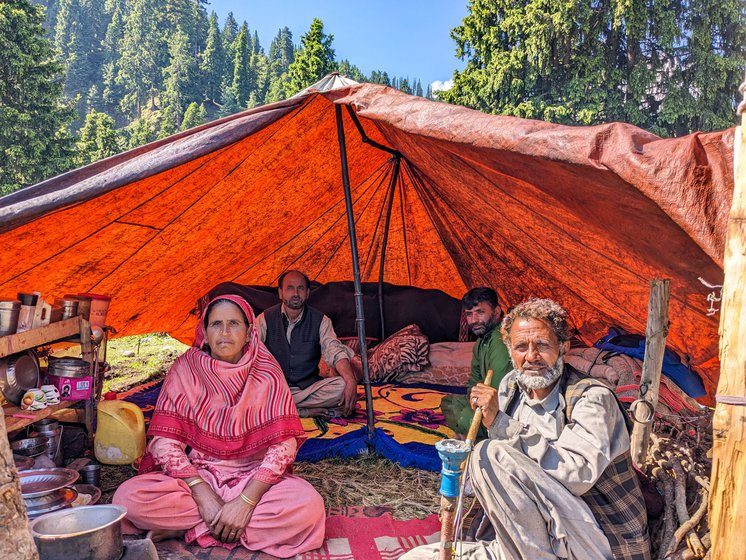 Mohammed Younus (left) on the banks of the Shaliganga river in Doodhpathri where he and his family have come with their livestock. They will continue to move upstream till the source of the river in search of fresh pastures. Inside their tent, (in the front) his spouse Zubeda Begam and his brother (with the hookah)
